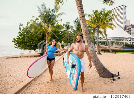 Two young surfers with boards on the beach Two young surfers with boards on the beach 132917462