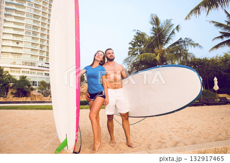 Two young surfers with boards on the beach Two young surfers with boards on the beach 132917465