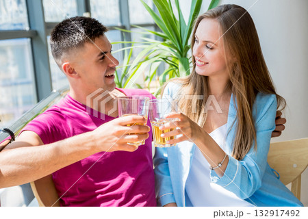 Cheerful couple in the pub. Drinking beer, talking, having fun. Cheerful couple in the pub. Drinking beer, talking, having fun. 132917492