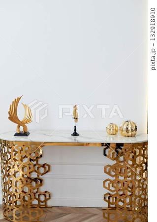A table with a metallic gold underframe. Luxurious minimalist interior. White and gold palette, A table with a metallic gold underframe. Luxurious minimalist interior. White and gold palette, 132918910