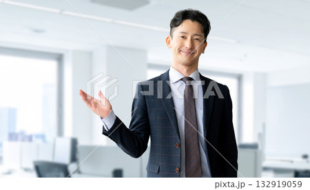 笑顔で案内する男性ビジネスマン 132919059
