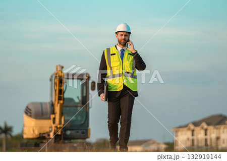Building supervisor has phone call. Chief engineer in hardhat use phone. Businessman talk on phone. Civil engineer man. Supervisor business man. Man at building site. Business project communication 132919144