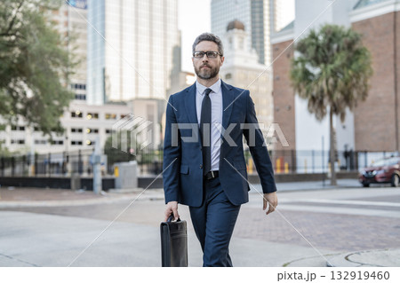 Businessman in suit walk outdoor. Walk to success. Businessman walk in the city. Business man crossing the street. Walk of business man. Businessman in New York. Business success Businessman in suit walk outdoor. Walk to success. Businessman walk in the city. Business man crossing the street. Walk of business man. Businessman in New York. Business success 132919460