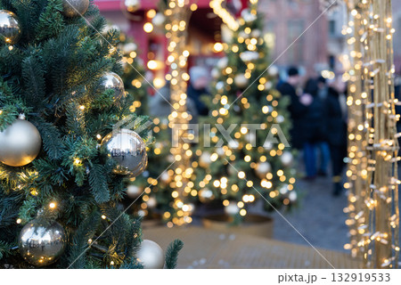Christmas tree at a festive fair with a side and a garland, a blurry background 132919533
