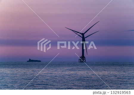 Tranquil sunset over Miaoli coastline with an offshore wind turbine. Tranquil sunset over Miaoli coastline with an offshore wind turbine. 132919563