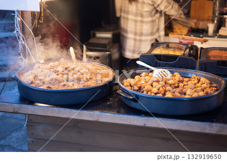 Prepared street food at a Christmas market, potatoes and cabbage, bigos, a national Polish food. Prepared street food at a Christmas market, potatoes and cabbage, bigos, a national Polish food. 132919650