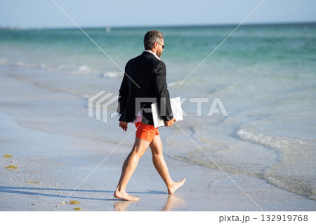 Freelancer business man on summer vacation. Summer weekend and remote freelance work. business man with laptop. Business man dreams on summer in sea. Summer business. Journey to relaxation 132919768