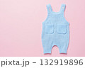 Baby blue knitted onesie on pink background. Fashion newborn clothes. Flat lay top view. Wool kid soft clothing. Infant trendy bodysuit made of organic eco cotton. Children wardrobe. Baby garment 132919896