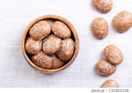 Gingerbread cookies, sugar glazed Christmas cookies, in a wooden bowl, on linen. Spice cookies, made of flour, sugar, and eggs, flavored with ginger, nutmeg, cloves, and cinnamon. From above. Photo Gingerbread cookies, sugar glazed Christmas cookies, in a wooden bowl, on linen. Spice cookies, made of flour, sugar, and eggs, flavored with ginger, nutmeg, cloves, and cinnamon. From above. Photo 132920108