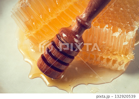 honeycomb, with a wooden spoon-spindle, on a plate, no people, 132920539