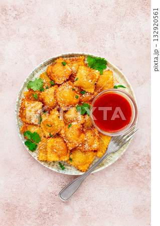 fried ravioli with parmesan cheese, served with red sauce and garnished with herbs, on a light background, no people, fried ravioli with parmesan cheese, served with red sauce and garnished with herbs, on a light background, no people, 132920561