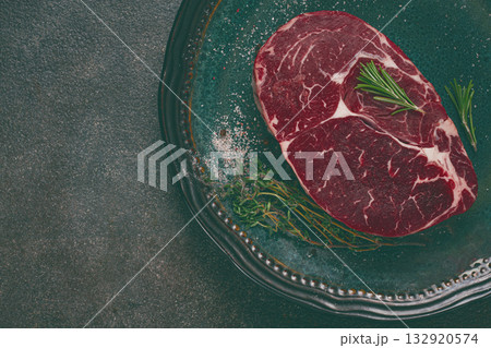 Steak made from fresh beef, with herbs and various spices, on a plate, ready to cook, there are no people Steak made from fresh beef, with herbs and various spices, on a plate, ready to cook, there are no people 132920574