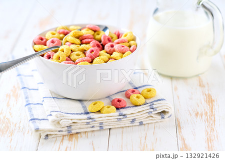 ceramic bowl of tasty corn rings and strawberry rings on a light kitchen table, selective focus. ceramic bowl of tasty corn rings and strawberry rings on a light kitchen table, selective focus. 132921426