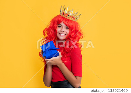 child smile in crown with present on yellow background 132921469