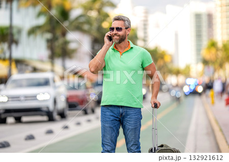 Tourist booking vacation trip. Traveler suitcase for summer trip. Man booking summer trip. Hispanic tourist traveler book online. Tourist with travel bag. Traveler using phone. Voyage lifestyle Tourist booking vacation trip. Traveler suitcase for summer trip. Man booking summer trip. Hispanic tourist traveler book online. Tourist with travel bag. Traveler using phone. Voyage lifestyle 132921612