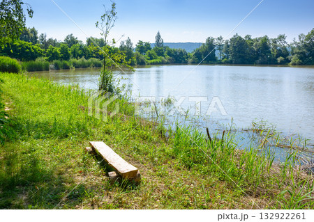 lake near forest. beautiful view of a nature landscape in summer. calm sunny morning in carpathian mountains. country scenery under clear blue sky. vacations in remote place 132922261