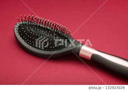 Massage hairbrush on red background. Space for text 132923026