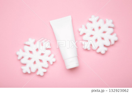 Winter skin care concept. Cosmetic moisturizer cream and snowflakes on pink background. 132923062
