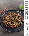 Fried teriyaki beef with sesame seeds and green onions on a brown background. Asian cuisine. 132923868