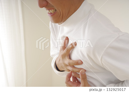 突然の発作に胸を押さえて苦しむ中年男性 132925017