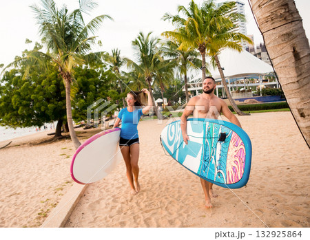 Two young surfers with boards on the beach Two young surfers with boards on the beach 132925864