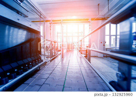 Automatic filling machine pours water into plastic PET bottles.  132925960