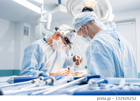 Spinal surgery. Group of surgeons in operating room with surgery equipment. Spinal surgery. Group of surgeons in operating room with surgery equipment. 132926252