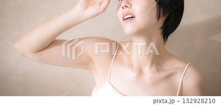 ピンクベージュの背景で日射しを気にして眩しい女性 uvや太陽、日焼け止めのイメージ 顔無しのバナー ピンクベージュの背景で日射しを気にして眩しい女性 uvや太陽、日焼け止めのイメージ 顔無しのバナー 132928210
