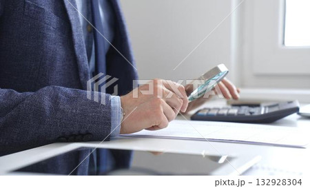 Financial analyst reviewing accounting reports, calculating data with calculator and magnifying glass on corporate workspace. Audit and taxes in business Financial analyst reviewing accounting reports, calculating data with calculator and magnifying glass on corporate workspace. Audit and taxes in business 132928304