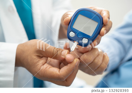 Doctor check diabetes from finger blood sugar level with finger lancet. Doctor check diabetes from finger blood sugar level with finger lancet. 132928393