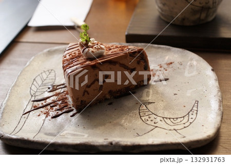 チョコソースがけチョコレートムースケーキの和柄陶器皿の一切れ  132931763