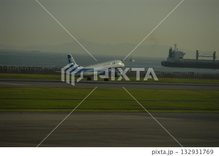 斜め構図で捉えたANA機のテイクオフ瞬間と海の貨物船 斜め構図で捉えたANA機のテイクオフ瞬間と海の貨物船 132931769