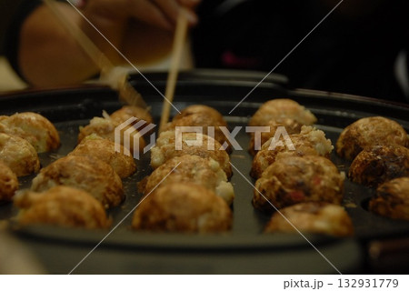 箸先でひっくり返される熱々たこ焼きのシズルショット  132931779