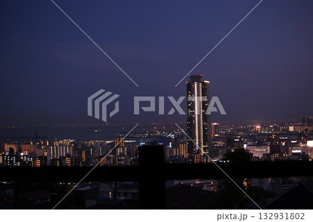 夜の都市を照らす高層タワーマンションと海辺の夜景パノラマ  132931802