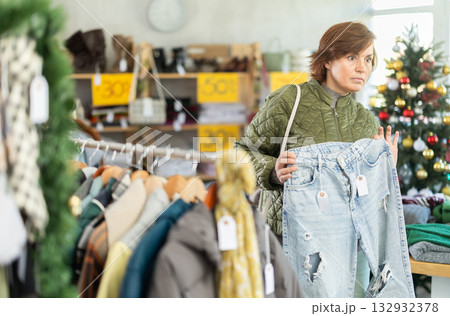 Adult woman choosing jeans in clothing store Adult woman choosing jeans in clothing store 132932378