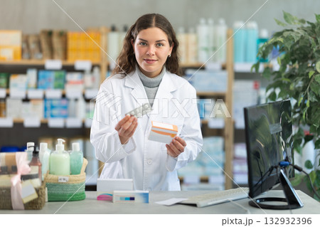 Young woman pharmacist offering pills Young woman pharmacist offering pills 132932396