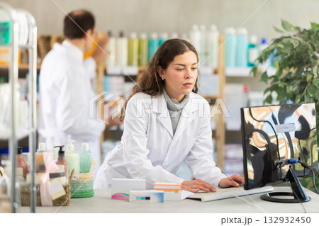 Female pharmacist looking for pills on computer Female pharmacist looking for pills on computer 132932450