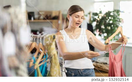 Adult woman choosing jumpsuit in clothing store Adult woman choosing jumpsuit in clothing store 132932514