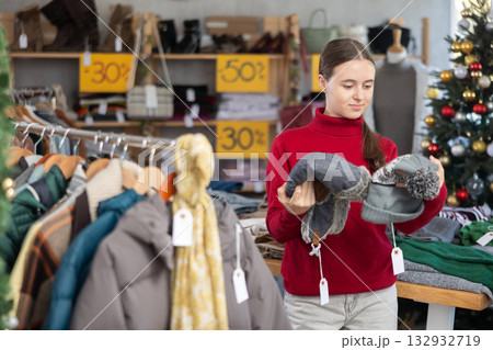 Teenage girl choosing hat in clothing store 132932719