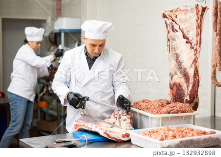Adult male butcher sawing beef ribs 132932898