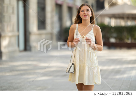 Young woman looks around on city street Young woman looks around on city street 132933062