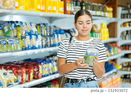 Young girl choosing packaged green split peas in grocery store 132933072