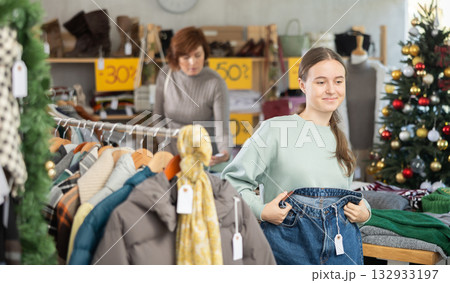 Teenage girl choosing jeans in clothing store Teenage girl choosing jeans in clothing store 132933197