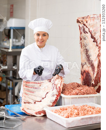 Young woman butcher holding beef ribs Young woman butcher holding beef ribs 132933260