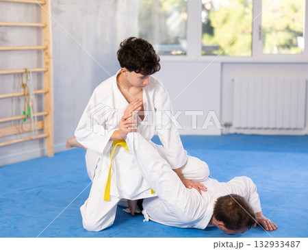 Man and teenage boy train judo fighting techniques Man and teenage boy train judo fighting techniques 132933487