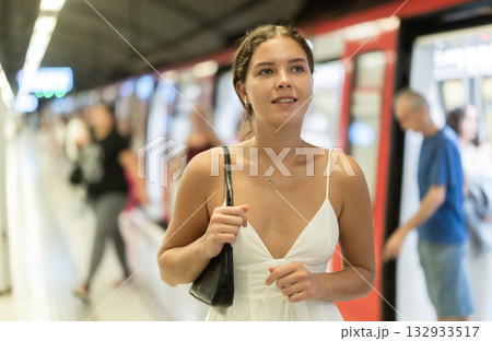 Young girl standing on platform of underground station 132933517