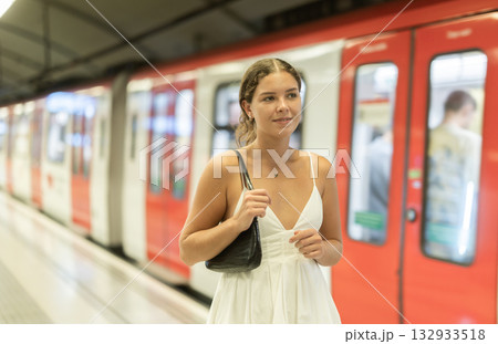 Young woman standing on platform waiting for train Young woman standing on platform waiting for train 132933518