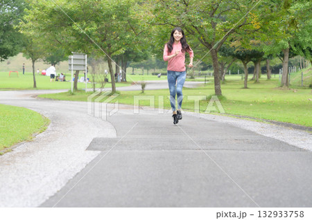 公園をランニングする女性 132933758