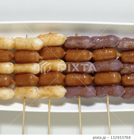 Sotteok-sotteok, a popular Korean street food featuring skewers of sausages and rice cakes, grilled to perfection and glazed with a sweet and spicy sauce. Perfect for food photography Sotteok-sotteok, a popular Korean street food featuring skewers of sausages and rice cakes, grilled to perfection and glazed with a sweet and spicy sauce. Perfect for food photography 132933768