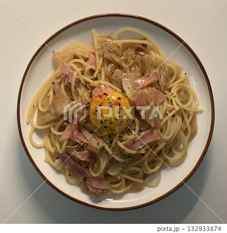 A plate of spaghetti pasta, perfectly cooked and topped with rich marinara sauce and fresh herbs. Ideal for food photography and menus, capturing the heart of Italian cuisine in a delicious way. 132933874